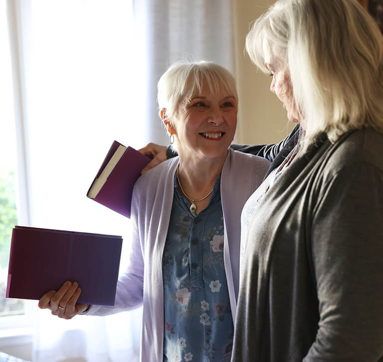 Nina and her friend, smiling at each other
