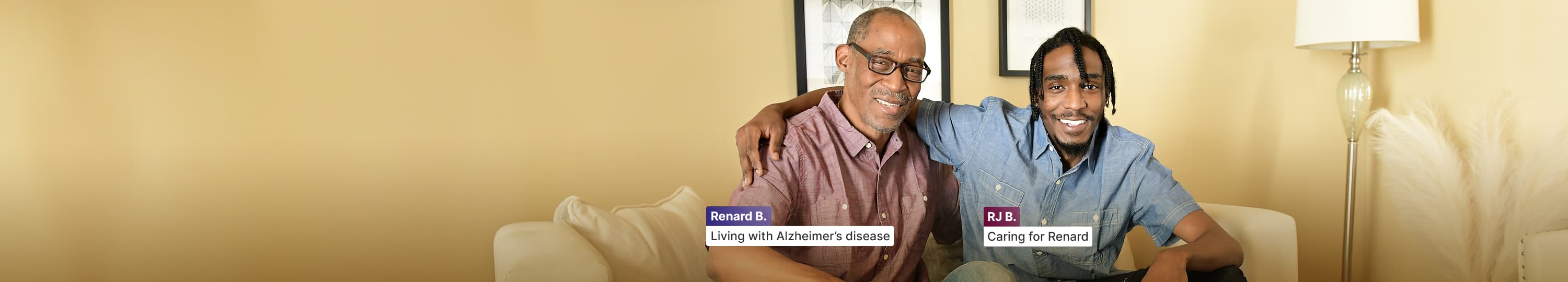 Renard, who is living with Alzheimer’s disease, arm in arm with RJ, his care partner on a sofa