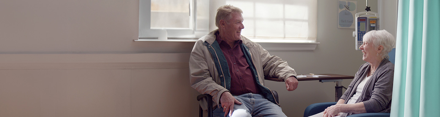 Nina, una paciente con Alzheimer temprano, y su esposo Greg se sonríen en un centro de infusión